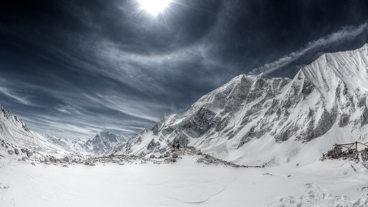 Snow-covered ground and steep peaks on the Larkya La Pass, the highest point of the Manaslu Circuit